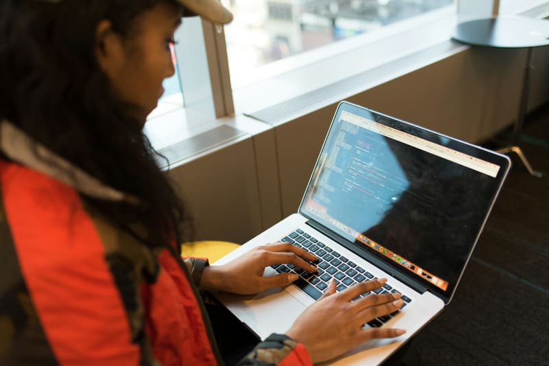 A woman writing code on a laptop — licensed illustration, not a person in the BLS count. Texas.