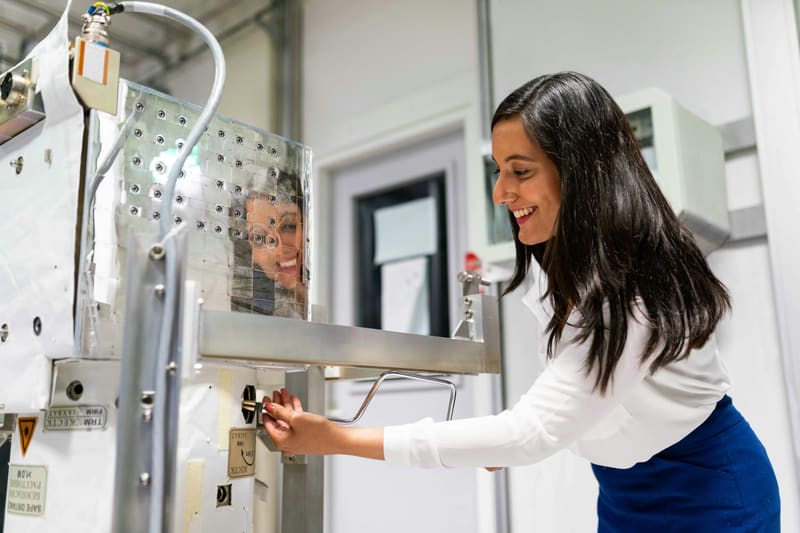 A woman adjusting a component on laboratory equipment — licensed illustration, not a person in the BLS count. Gray County, Texas.