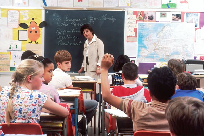 A woman teaching at the front of a classroom — licensed illustration, not a person in the BLS count. Pendleton County, Kentucky.