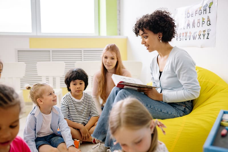 A woman reading with young children — licensed illustration, not a person in the BLS count. Lee County, Texas.